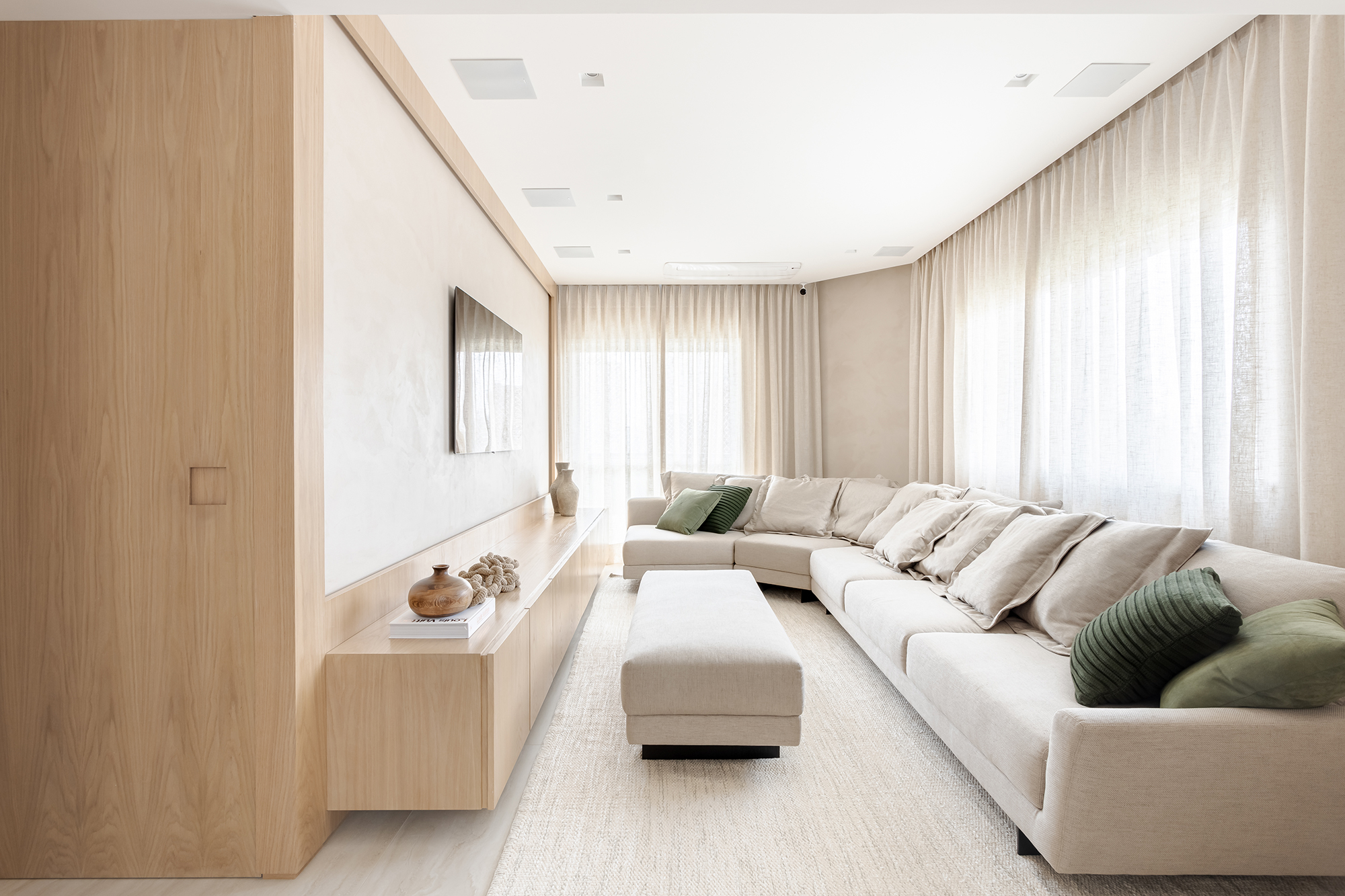 Adega walk-in e muita madeira marcam este apartamento de 300 m². Projeto de Figueiredo Fischer Arquitetos. Na foto, sala de TV com marcenaria clara e sofá.