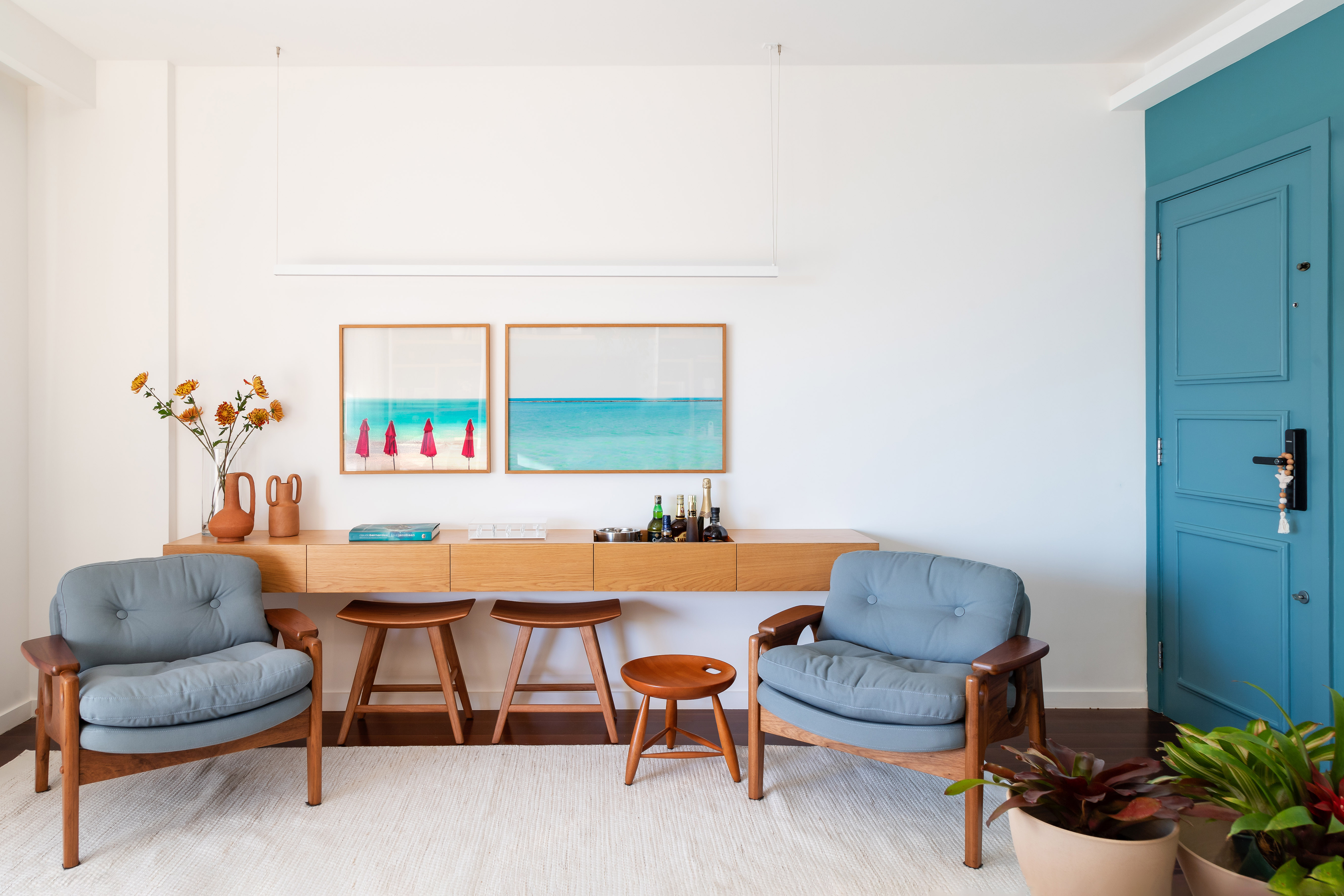 Apartamento de 140 m² ganha charme com paredes azuis e verdes. Projeto de Maia Romeiro Arquitetura. Na foto, sala com aparador e poltrona.