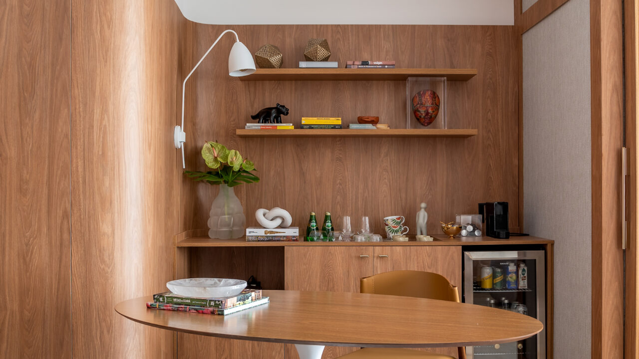 Ana Weege assina consultório psicológico com cara - e aconchego! - de casa. Na foto, sala de espera com bar, parede curva e prateleiras.