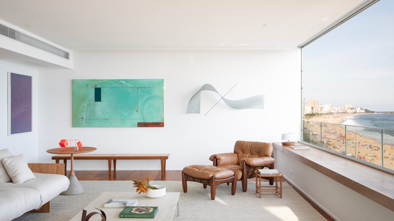 À beira-mar, apartamento minimalista ganha ares de galeria de arte. Projeto de João Panaggio. Na foto, sala de estar com quadro, poltrona mole e aparador.