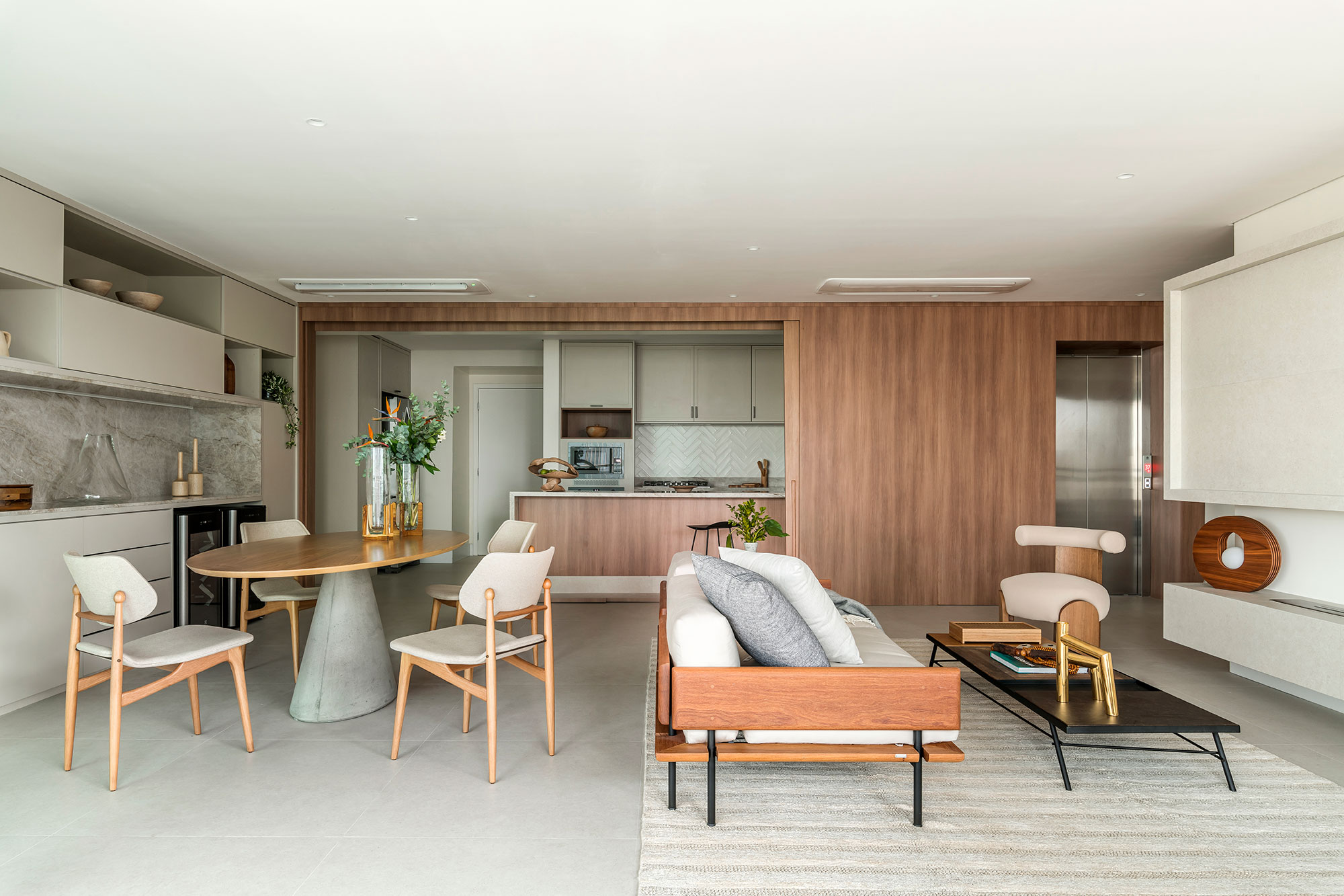 Apartamento de 197 m² feito para receber e curtir em família. Projeto de Mariana Leal, do Morada 31.12. Na foto, sala de estar e jantar integradas e cozinha camuflada na porta de correr.
