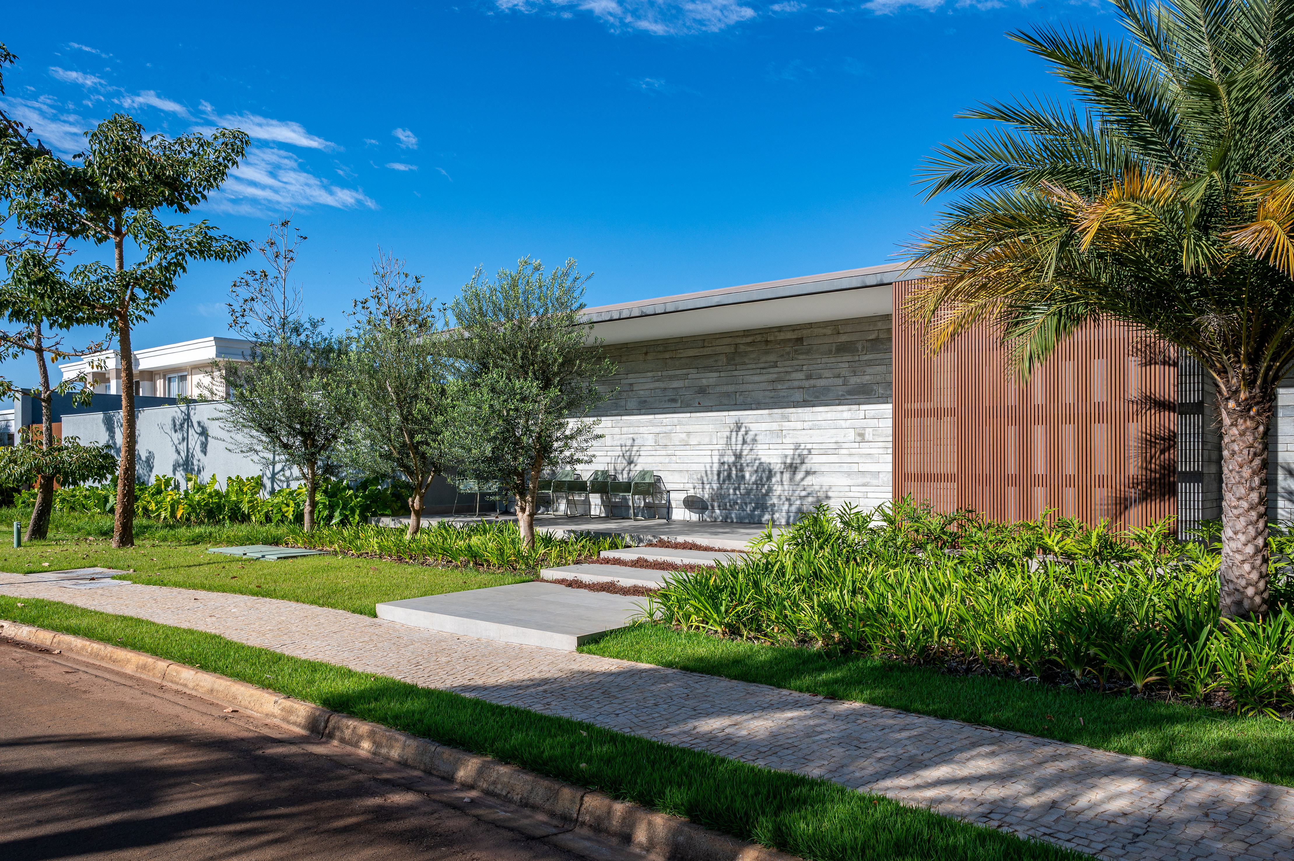 Jardim de 1710 m² ganha pista de caminhada e paisagismo tropical. Projeto de Flávia D´Urso. Na foto, fachada com jardim.