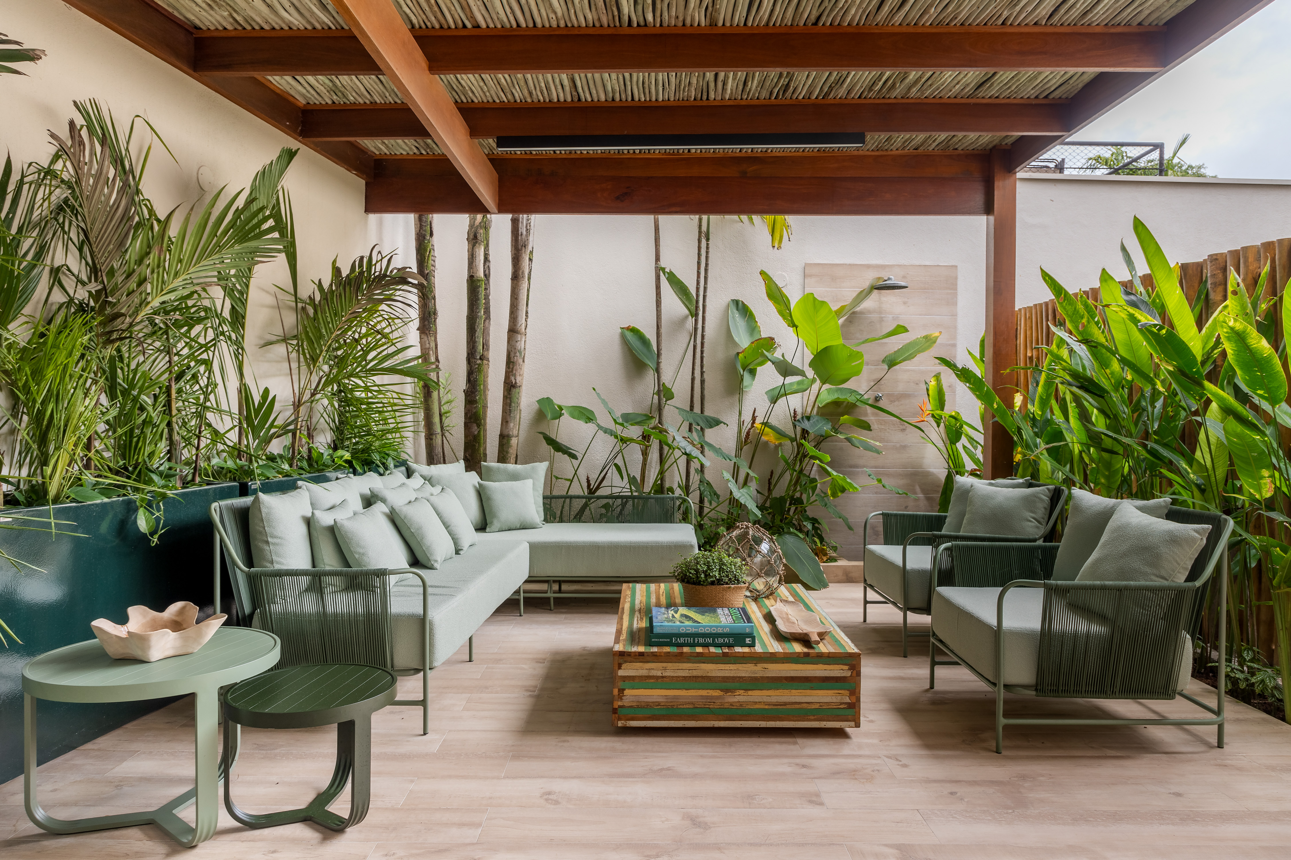 Casa de praia ganha décor fresh, com cores claras e tons neutros. Projeto de Beatriz Quinelato. Na foto, varanda com cobertura de bambu e jardim.