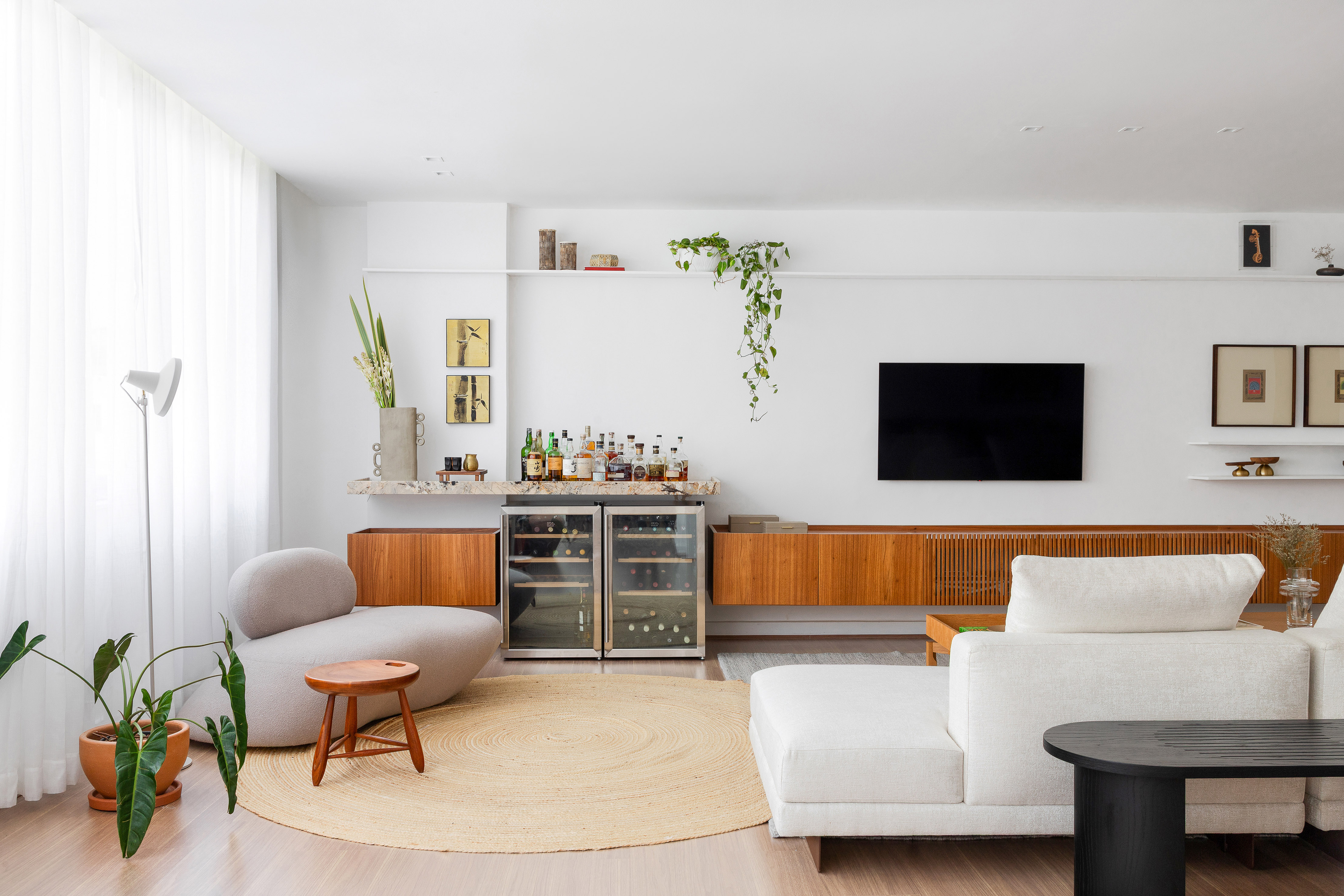 Sem quebra-quebra, cobertura de 490 m² ganha décor com peças soltas. Projeto de Rafael Ramos. Na foto, sala com aparador, tv e bar,
