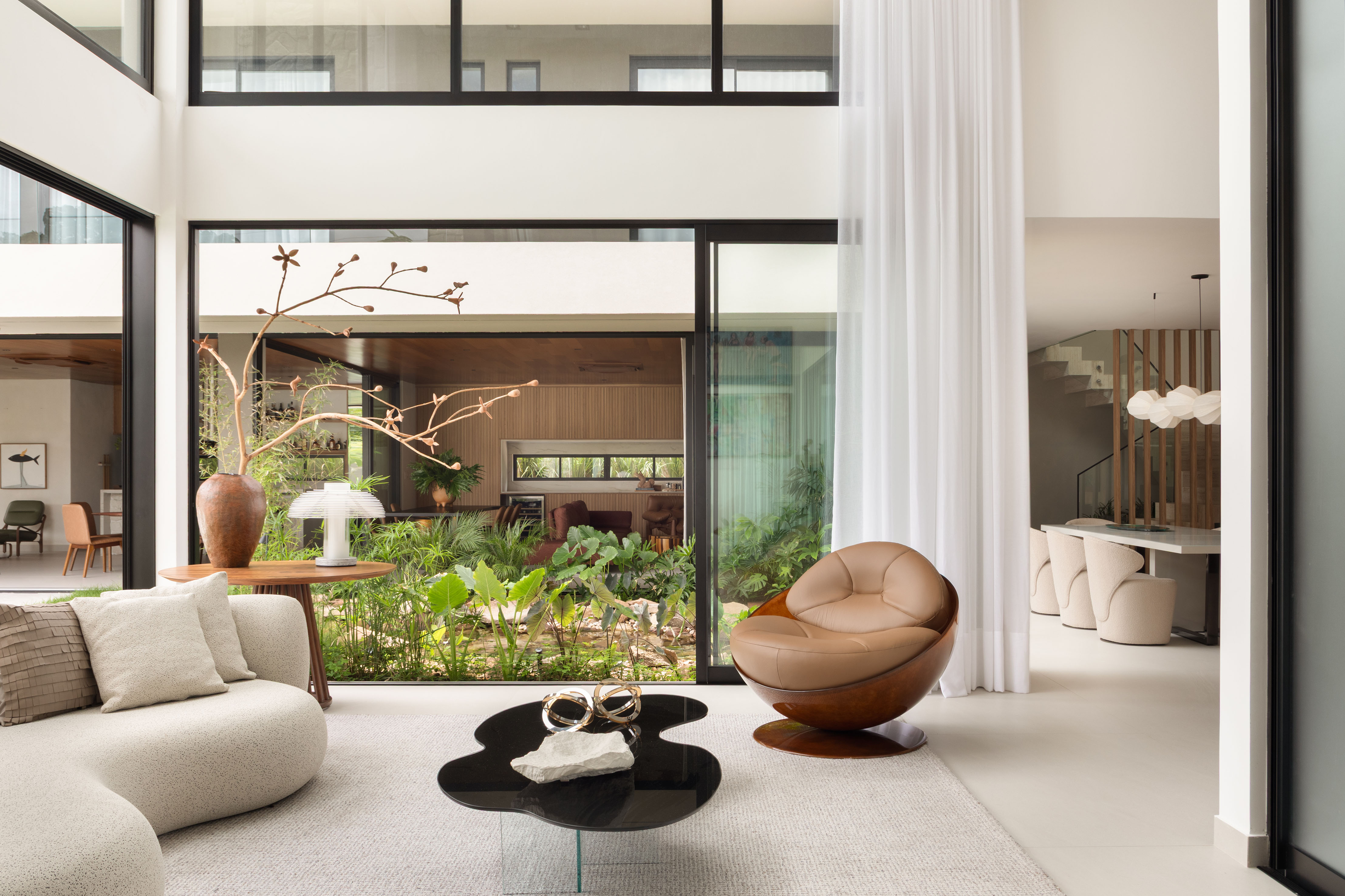 Feita do zero, casa em Teresina ganha lago e muito design nacional. Projeto de José Ribeiro. Na foto, sala com jardim interno e pé-direito duplo.