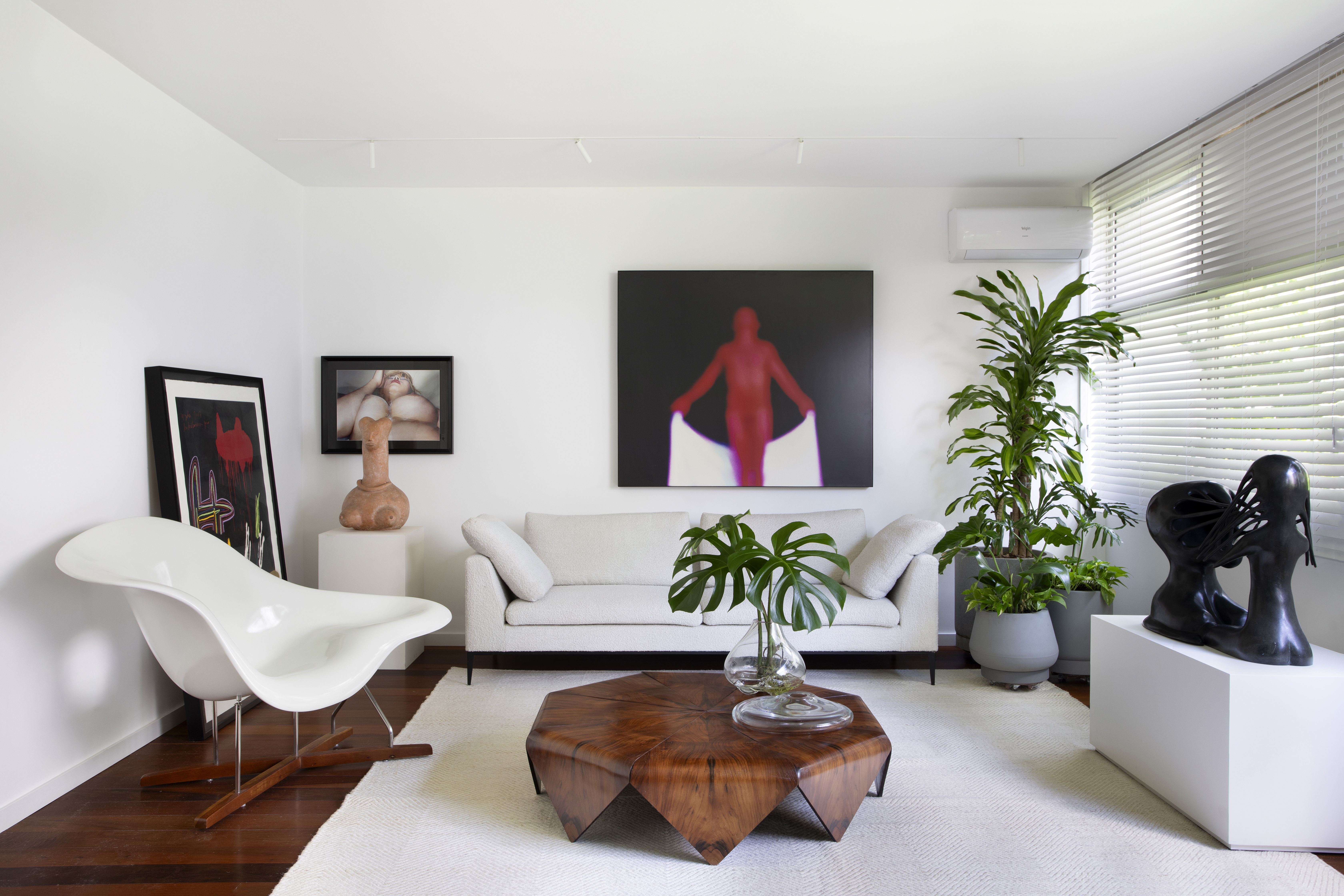 Mais de 100 obras de arte compõem décor de apê com ares de galeria. Projeto de Fabiano Ravaglia. Na foto, sala com sofá, quadros e plantas.