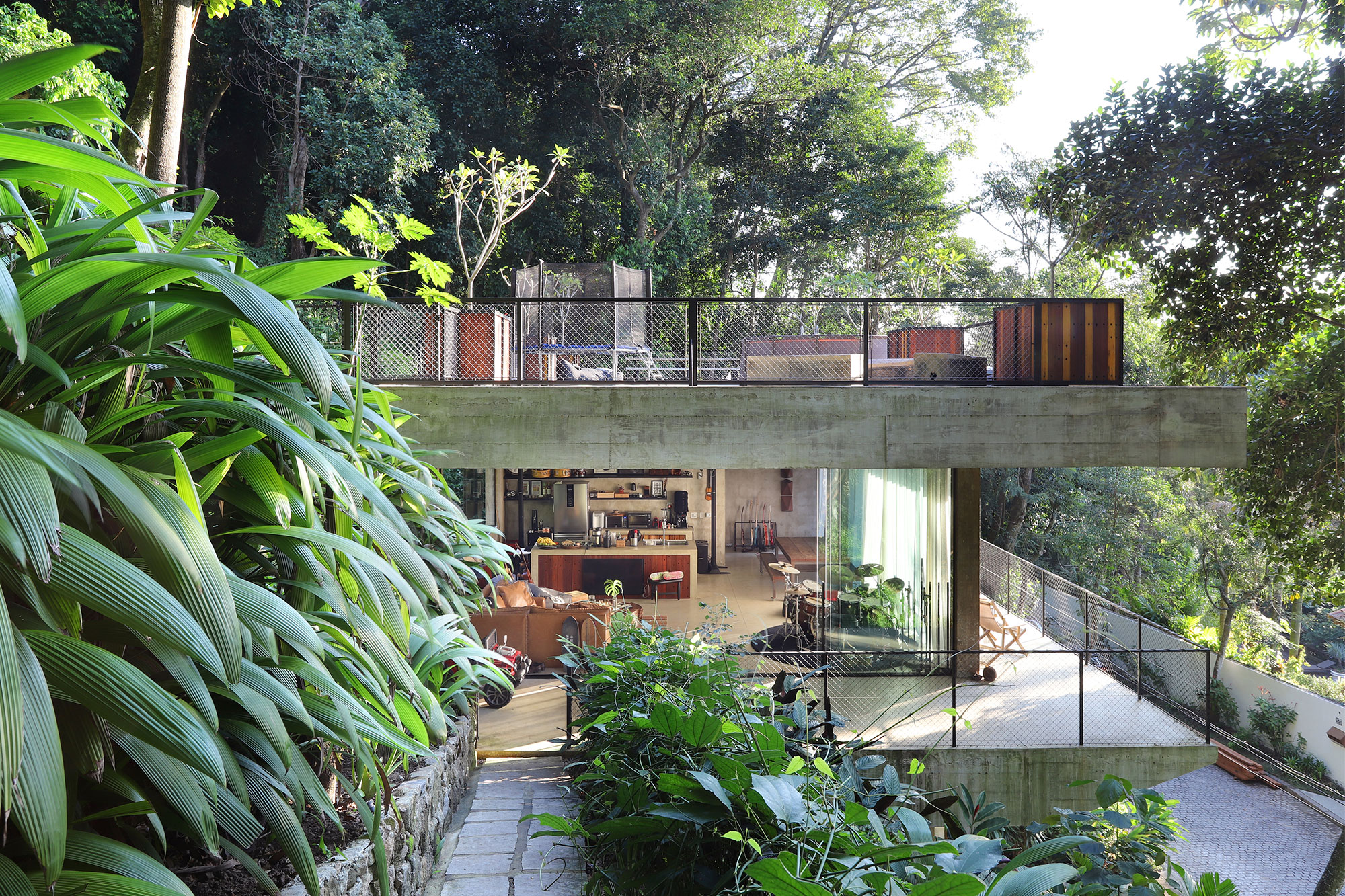 Conheça a casa cercada de verde do ator e músico Dudu Azevedo. Projeto de Pedro Coimbra. Na foto, fachada e jardim.