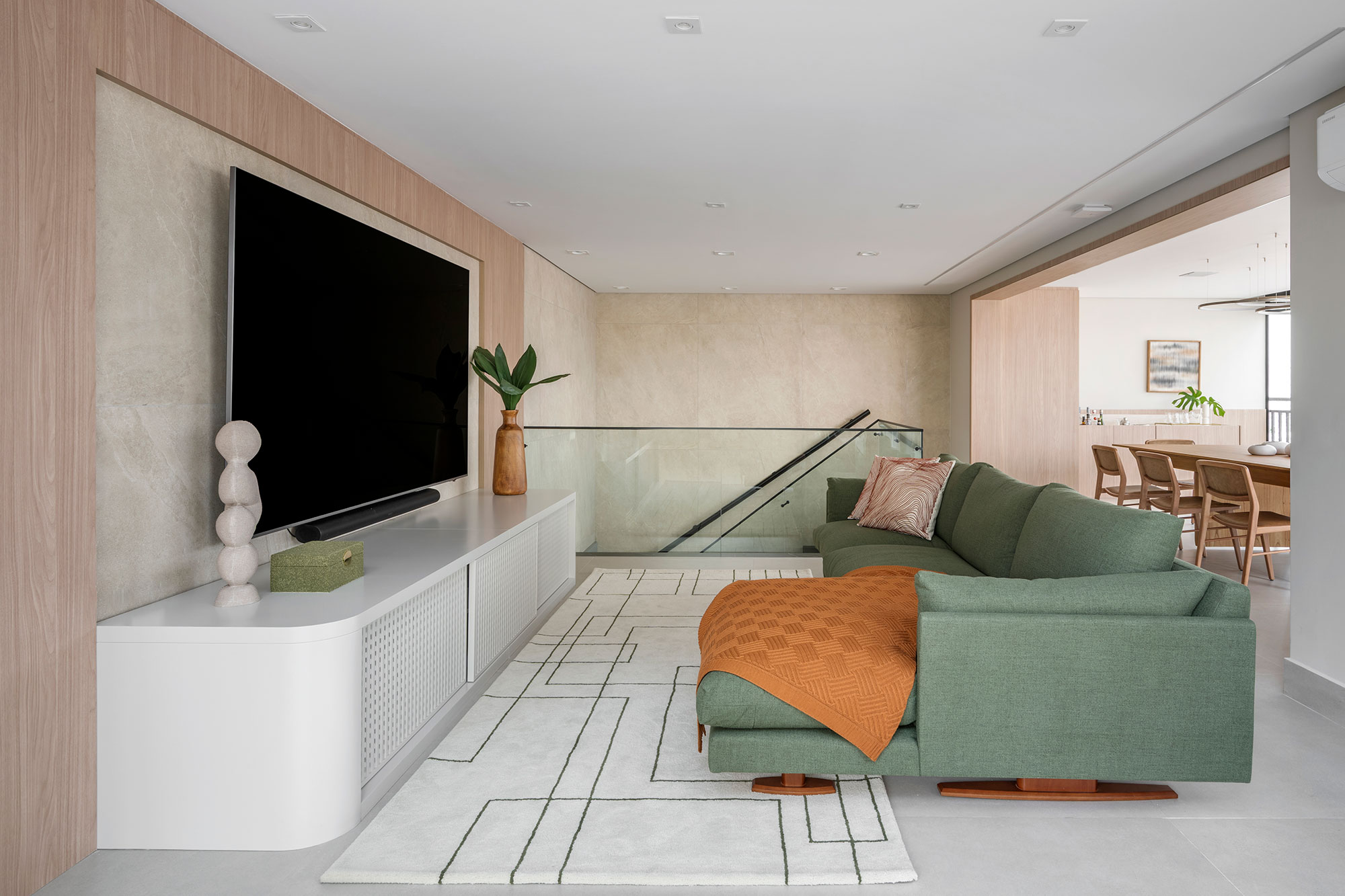 Duplex ganha cara de casa com área externa repleta de verde. Projeto de Erica Salguero. Na foto, mezanino com sala de TV.