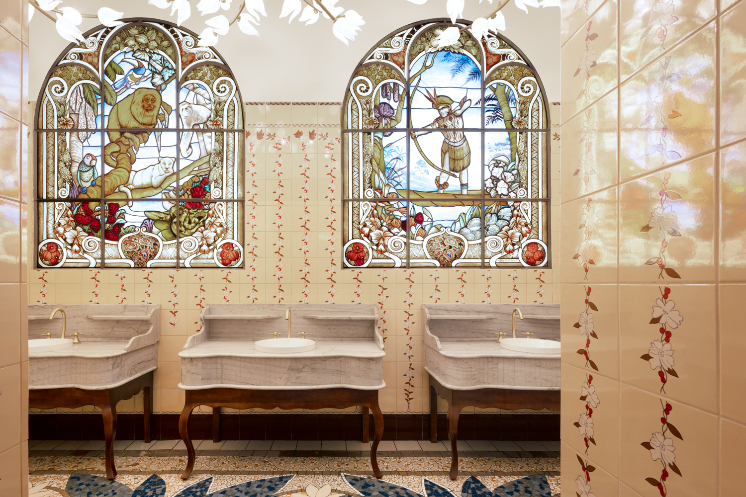 Fichberg Arquitetura e Interiores - Déjà Vu. Os sócios Eloy e Felipe Fichberg combinam memórias do estilo art nouveau com a exuberância da fauna, flora e cultura brasileiras em um recanto contemplativo de 49 m². Na área do banheiro, chamam a atenção os vitrais que retratam povos indígenas e a Mata Atlântica. Já o piso de mosaico, produzido com porcelanato reutilizado, exibe figuras de frutas tropicais, como cacau, açaí, abacaxi, jabuticaba e caju. Na sala, os profissionais fazem uma ponte entre passado e presente com a mistura de móveis clássicos e exemplares de design contemporâneo. Uma reflexão sobre representatividade feminina vem à tona por meio da obra da artista Silvana Mendes.