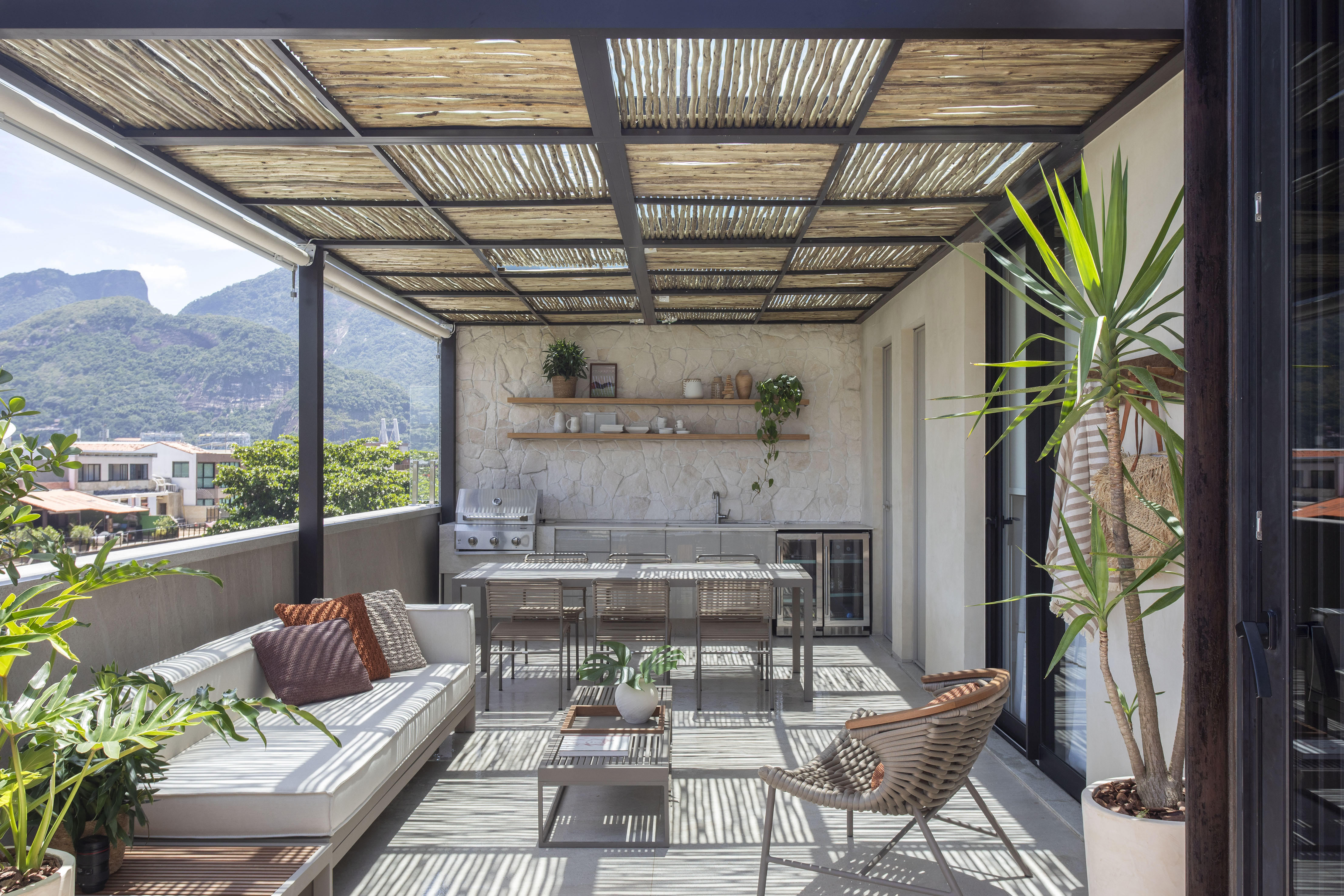 Duplex de 400 m² ganha novo andar de lazer com clima praiano. Projeto de Natália Lemos. Na foto, terraço com gourmet e sofá.