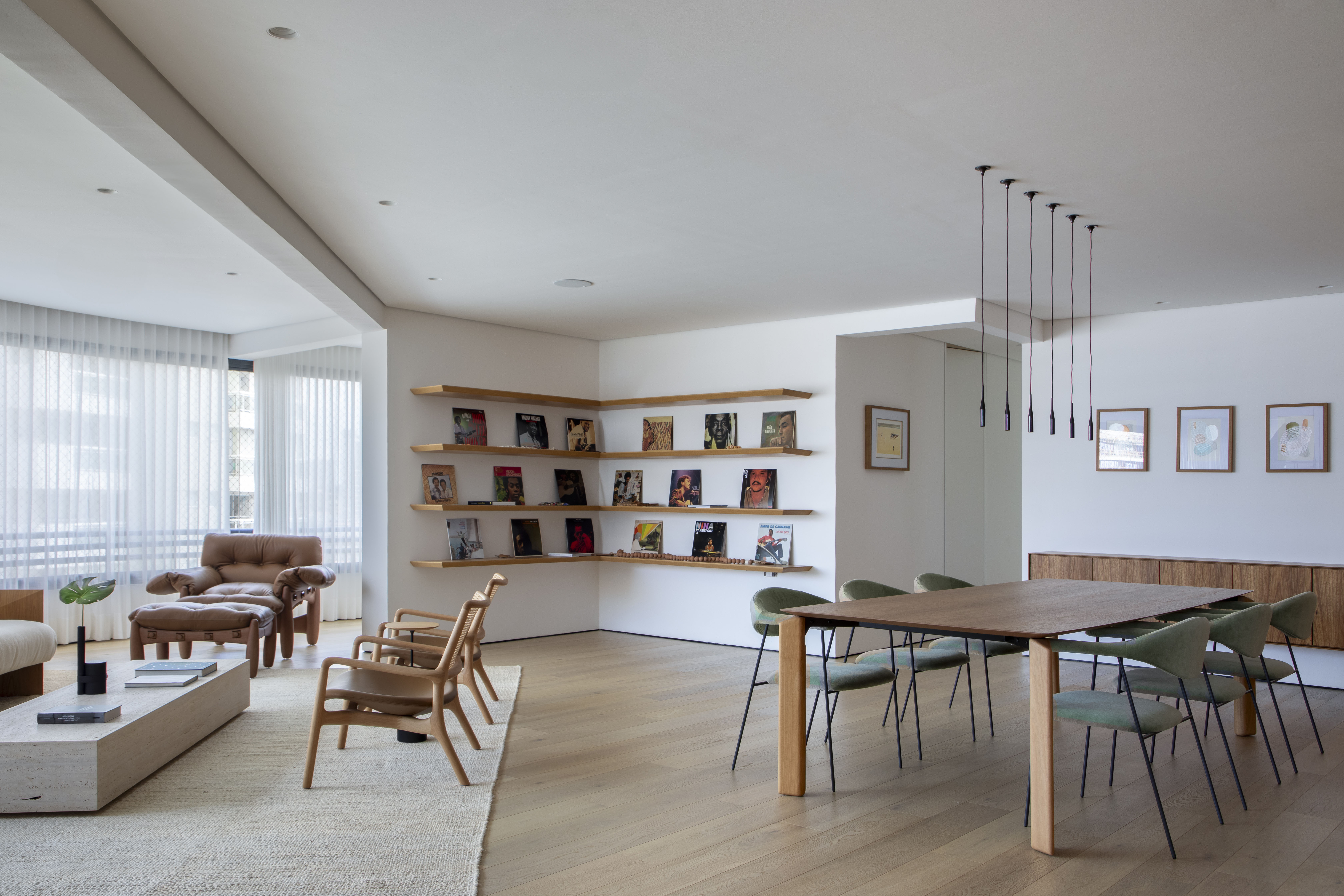 Integração de ambientes e paleta natural marcam apê de 220 m² no Piauí. Projeto de Vangii Guerra. Na foto, sala de estar com sofá, estante e cadeiras.